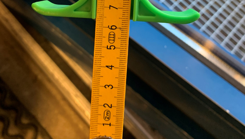 Bilde av tommestokk som viser resultat etter måling av terskelhøyde.